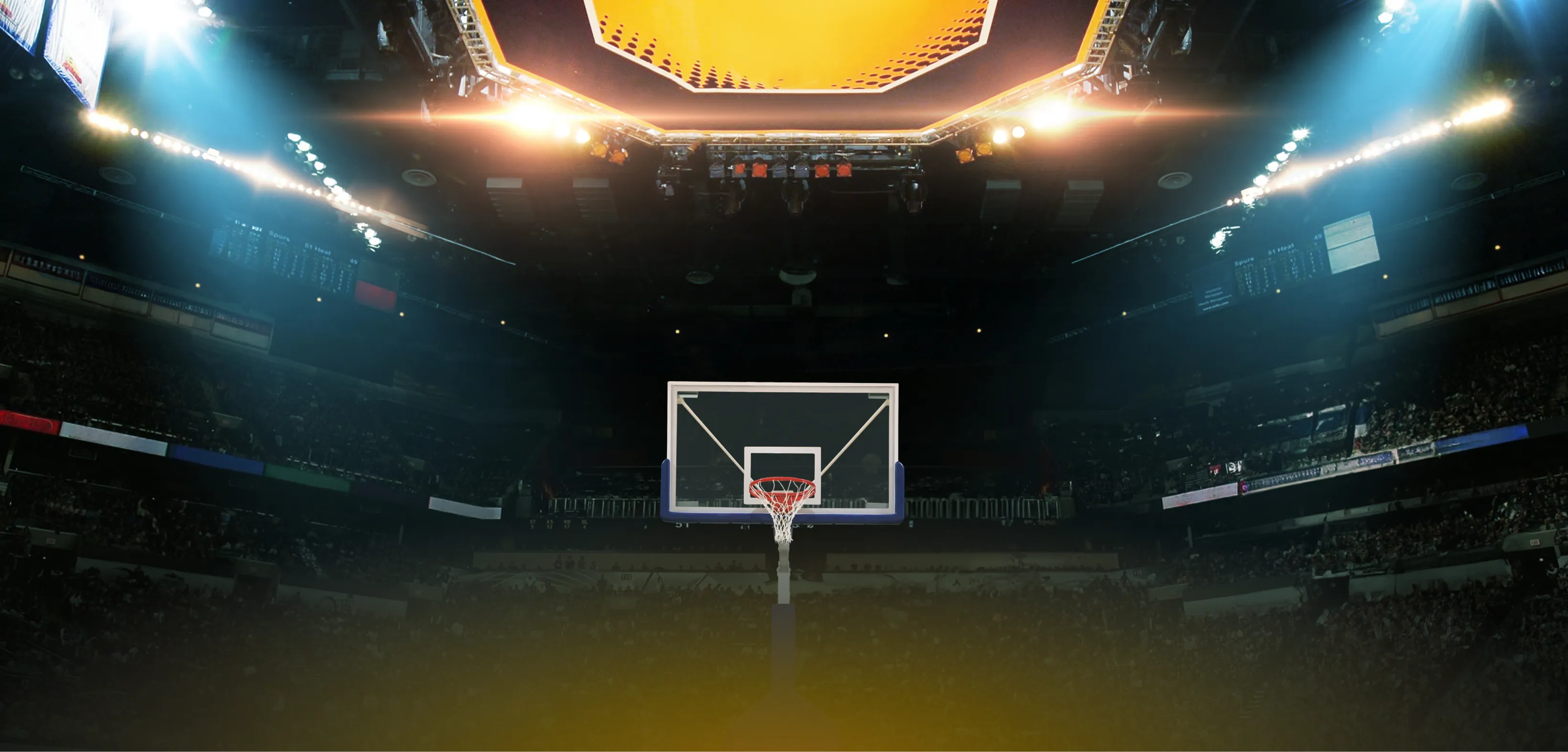 Basketball arena interior viewed from court level, with stadium lights and a full crowd