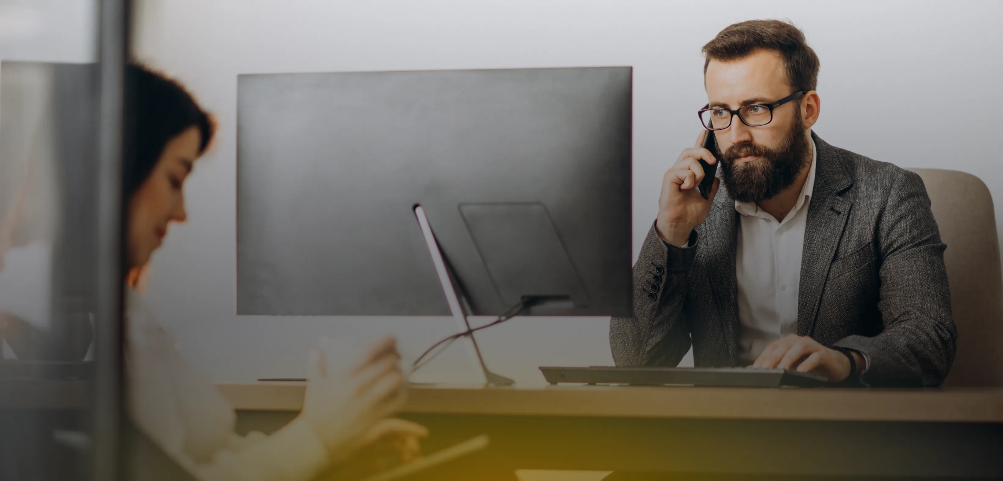 Finance professional taking a phone call at a desk in an open office