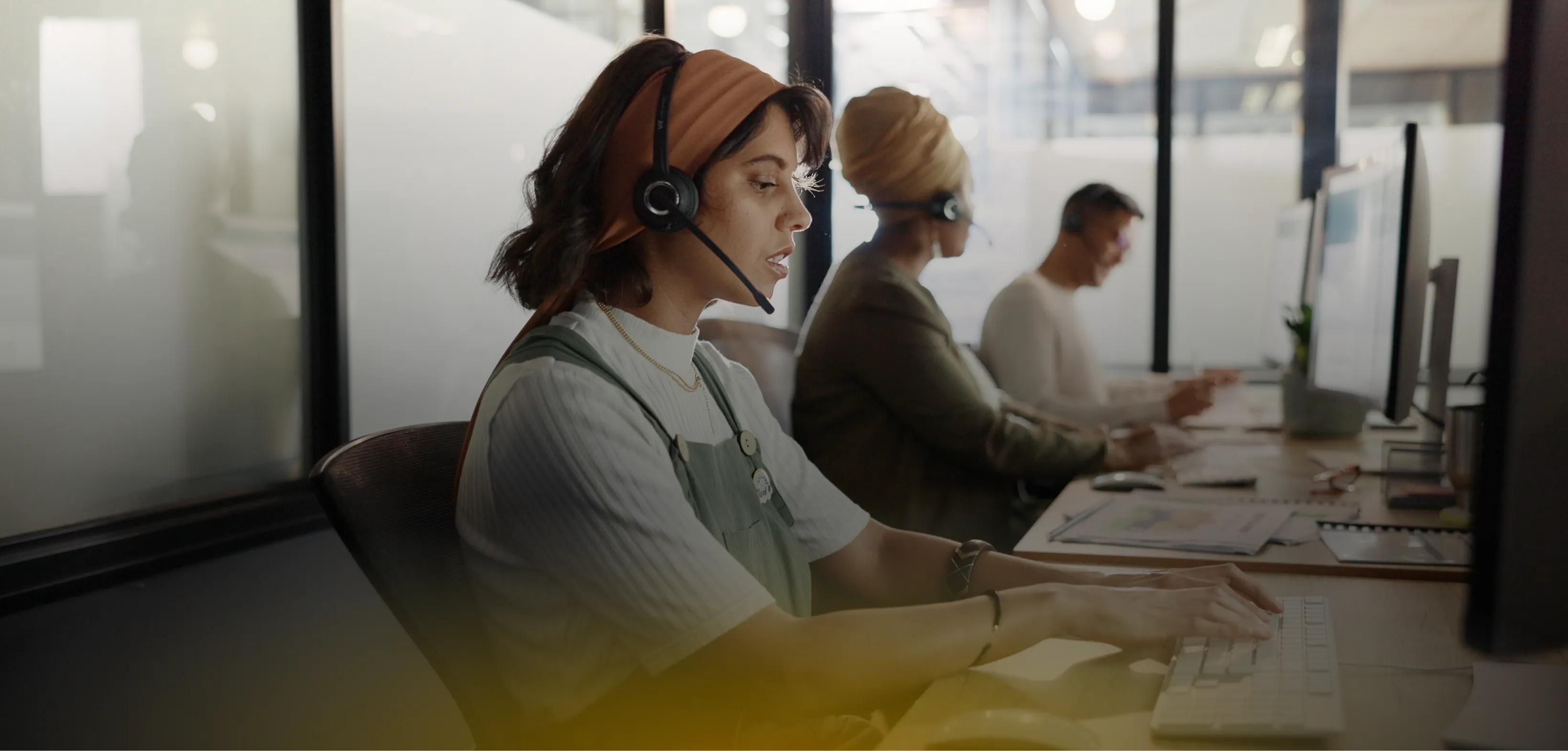 Customer-support team wearing headsets at their desks in an open office